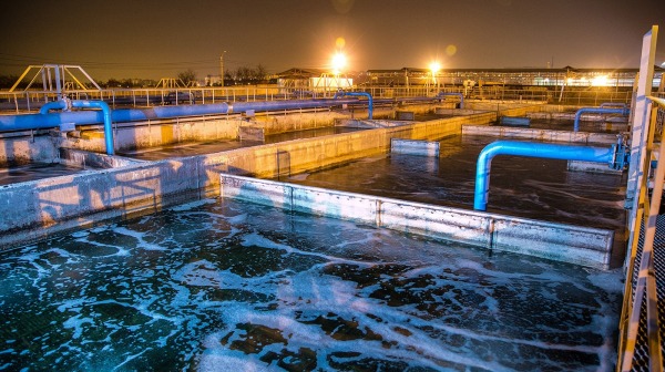Modern wastewater treatment plant of chemical factory at night. Water purification tanks
